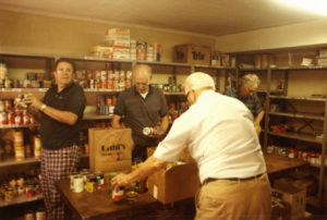 Pantry volunteers (L-R) Wil Dubes, Shaw Johnson, Dale Dallner and Warren Nixon sort food items in the basement of Central Presbyterian Church in September, 1984.